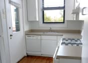 Thumbnail 32 of 48 - a small kitchen with white cabinets and a wood floor