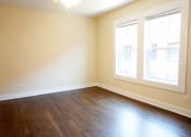 Thumbnail 24 of 38 - an empty room with wood floors and two windows