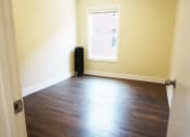 Thumbnail 18 of 38 - an empty room with a window and hardwood floors