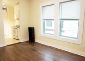Thumbnail 19 of 38 - an empty living room with two large windows and a stove in the background