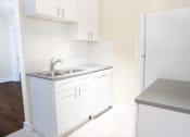 Thumbnail 27 of 38 - a small kitchen with white cabinets and a stainless steel sink