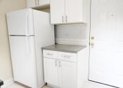 Thumbnail 28 of 38 - a small kitchen with white cabinets and a white refrigerator