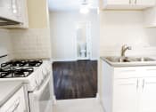 Thumbnail 23 of 38 - a kitchen with white cabinets and a white stove top oven