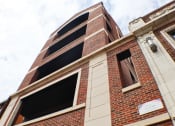 Thumbnail 4 of 23 - a view of the top of a brick building with a cloudy sky in the background