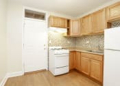 Thumbnail 12 of 38 - a kitchen with wooden cabinets and white appliances