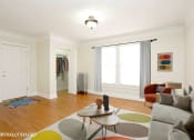 Thumbnail 5 of 38 - a living room with a gray couch and a colorful rug