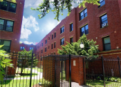 Thumbnail 2 of 38 - a red brick building with a black gate in front of it