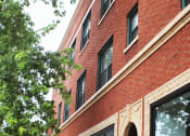 Thumbnail 42 of 48 - a red brick building with windows and a tree