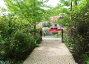 Thumbnail 48 of 48 - a walkway in front of a gate with a red car