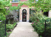 Thumbnail 40 of 48 - the entrance to a building with a brick sidewalk and plants