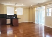 Thumbnail 9 of 23 - a kitchen and living room with wood floors and a sliding glass door