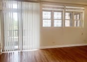 Thumbnail 14 of 23 - an empty living room with white blinds on the windows