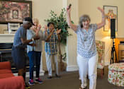 Thumbnail 105 of 109 - A group of people dancing in a living room.