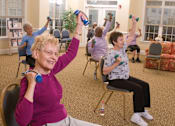 Thumbnail 103 of 109 - A group of elderly people exercising with dumbbells in a room.