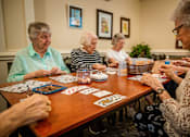 Thumbnail 93 of 109 - A group of elderly women playing a card game.
