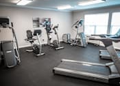 Thumbnail 60 of 109 - A gym with treadmills, exercise bikes, and other equipment.
