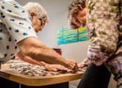 Thumbnail 109 of 109 - Two women playing a game of jigsaw puzzle.
