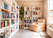 Thumbnail 61 of 109 - A room with a lot of books on the shelves and a chair in the middle.
