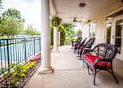 Thumbnail 90 of 109 - A row of black wicker chairs with red cushions are lined up on a porch.