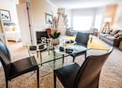 Thumbnail 80 of 109 - A glass dining table with four chairs in a living room.