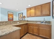 Thumbnail 66 of 74 - a kitchen with granite countertops and wooden cabinets