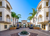 Thumbnail 57 of 74 - a courtyard with palm trees and a building in the background