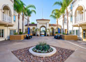 Thumbnail 49 of 74 - a courtyard with a fountain and palm trees at the preserve at great pond apartments in windsor