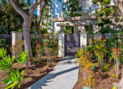 Thumbnail 63 of 74 - a walkway through a garden with trees and plants