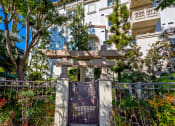 Thumbnail 64 of 74 - a gate leading to a white building with trees in front of it