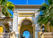 Thumbnail 50 of 74 - a building with a staircase and an archway with palm trees on either side