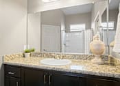 Thumbnail 14 of 36 - A bathroom with a granite countertop and a white sink.