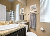 Thumbnail 15 of 36 - A bathroom with a toilet, sink, and towel rack.