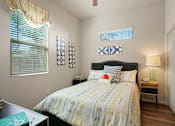Thumbnail 16 of 36 - A bedroom with a bed, nightstand, and window.