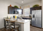 Thumbnail 1 of 36 - A kitchen with a table and chairs and a refrigerator.