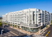 Thumbnail 1 of 33 - a large white building with a sign on it on a city street