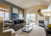 Thumbnail 3 of 17 - Living area with windows, fireplace, and sliding glass doors to patio at Bridgwater, Greenwood Village, CO