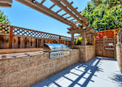 Thumbnail 8 of 40 - A patio with a grill and a pergola.
