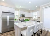 Thumbnail 50 of 60 - a white kitchen with stainless steel appliances and white chairs