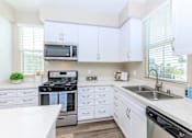 Thumbnail 52 of 60 - a kitchen with white cabinets and stainless steel appliances