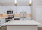 Thumbnail 60 of 72 - a kitchen with white cabinets and a white counter top