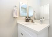 Thumbnail 57 of 60 - a white bathroom with a sink and a mirror