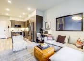 Thumbnail 1 of 18 - Modern Apartments in Downtown Oakland, CA - Edson House - Living Room With Recessed Lighting, Couch, Ottoman, Mirror, Corner Desk, and Area Rug.