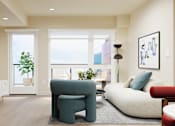 Thumbnail 35 of 117 - A living room with a blue chair and a white couch at Skyview Sunset Apartments, Los Angeles, CA, 90046