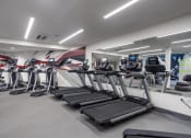 Thumbnail 13 of 33 - a gym with treadmills and weights in a building