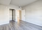 Thumbnail 6 of 18 - an empty living room with white walls and wood flooring