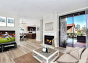 Thumbnail 1 of 57 - Living area with fireplace, TV, and sliding glass doors to balcony at Pointe Niguel, Laguna Niguel, California