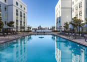 Thumbnail 4 of 33 - a large swimming pool in front of some tall buildings