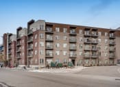Thumbnail 34 of 34 - Street View of Property Exterior with Grey and Brick Walls, Balconies, and Surrounding Trees at Waterford RiNo, Denver, 80216