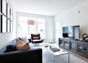 Thumbnail 26 of 33 - a living room with a black couch and a television