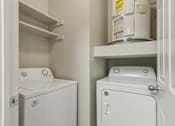 Thumbnail 28 of 40 - A white washing machine and dryer in a small laundry room.